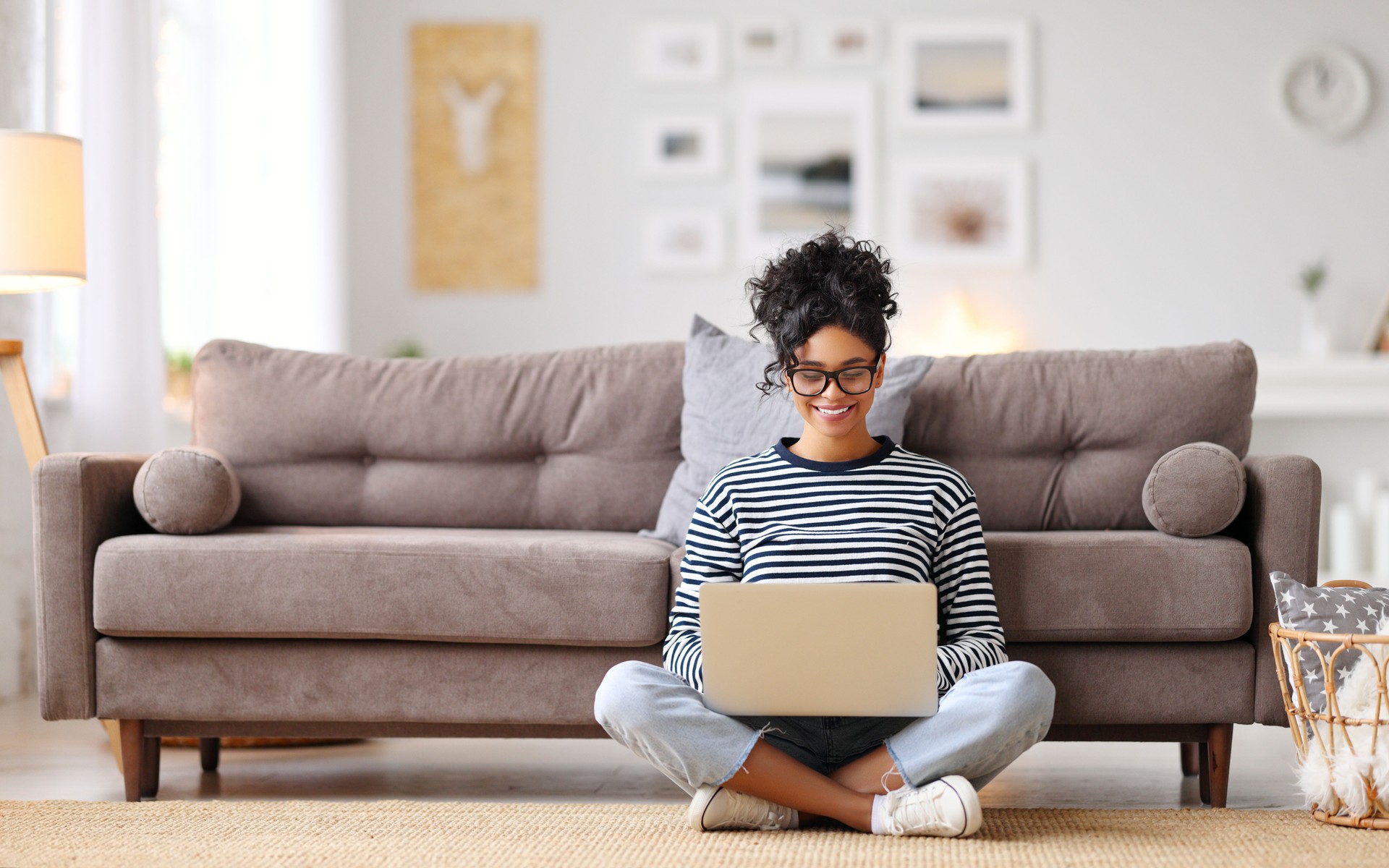 Joyful relaxed ethnic woman using laptop with interest at home